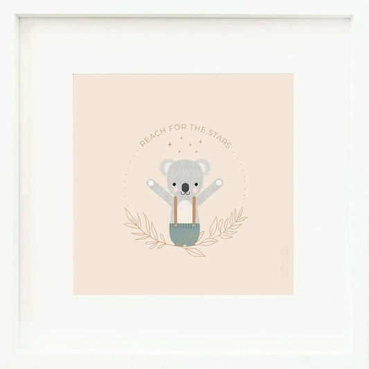 An inspirational print with a graphic of Quinn the koala with his arms in the air and the words “Reach for the stars” in brown. The background is blush-colored with drawings of leaves and stars.