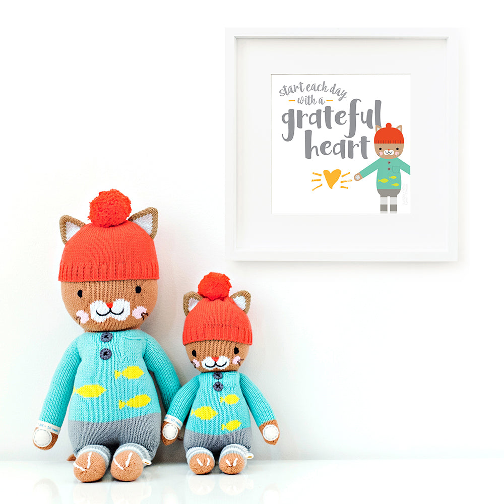 A framed print with a drawing of Maximus the cat and text that says “Start each day with a grateful heart.”